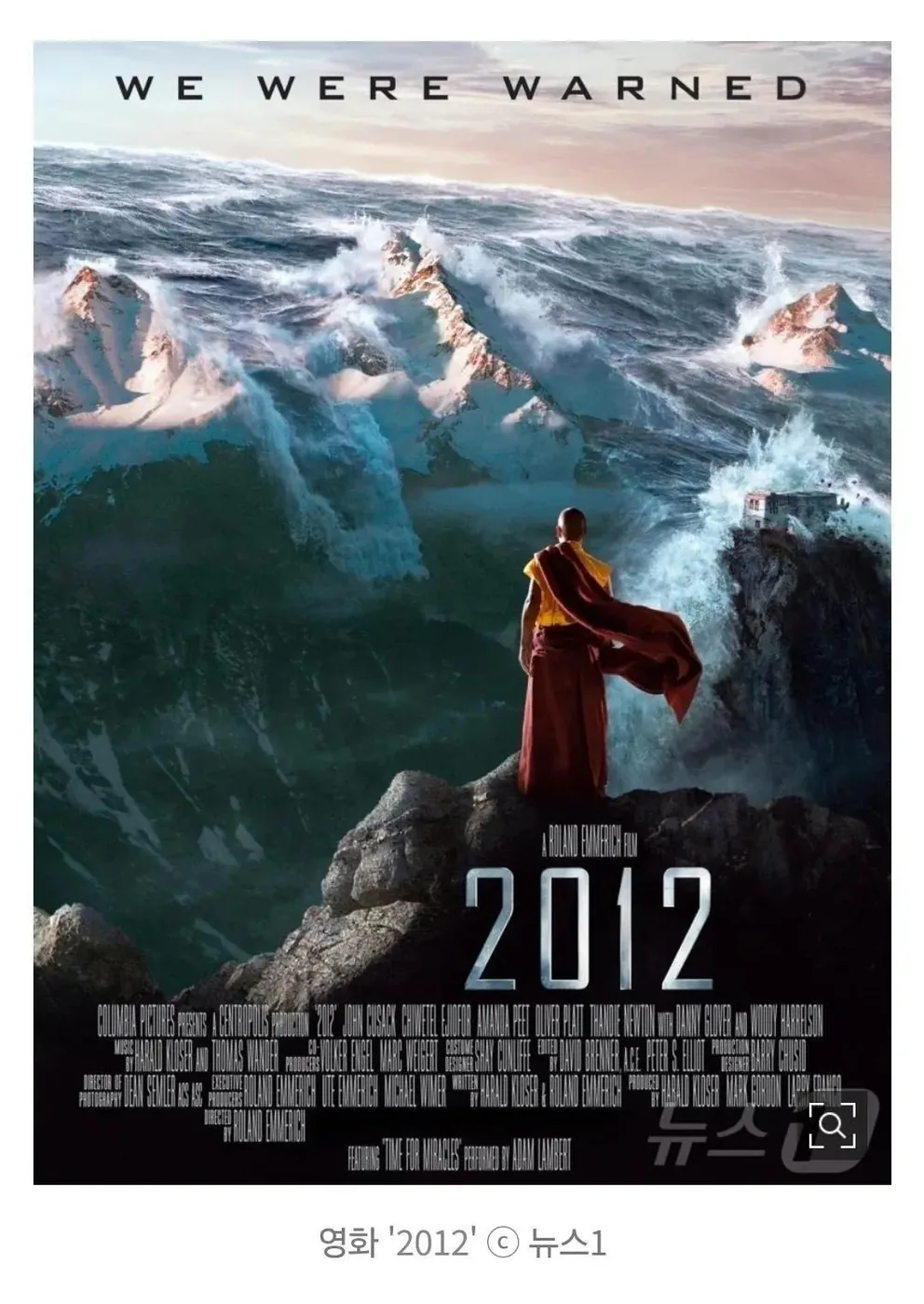 Poster quảng bá phim 2012 với nhà sư Himalaya đứng trước bức tường nước và dòng chữ We Were Warned